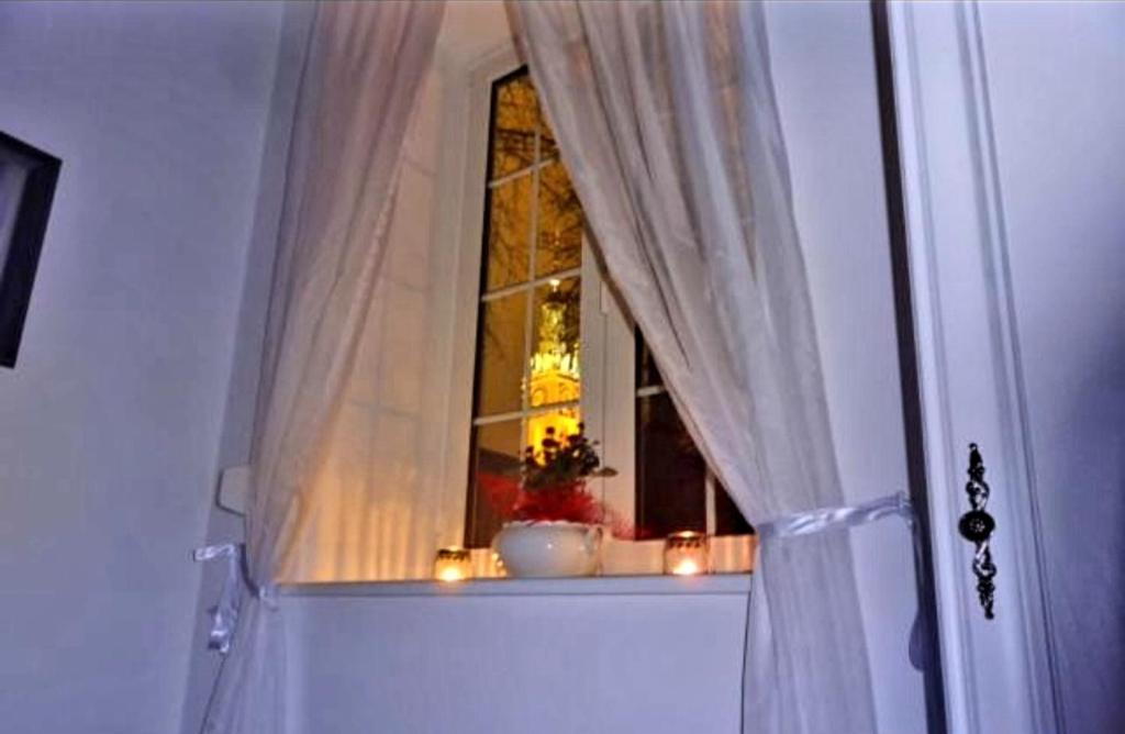 ein Fenster mit Kerzen auf einer Fensterscheibe mit einem Vorhang in der Unterkunft Old Town Apartment in Danzig
