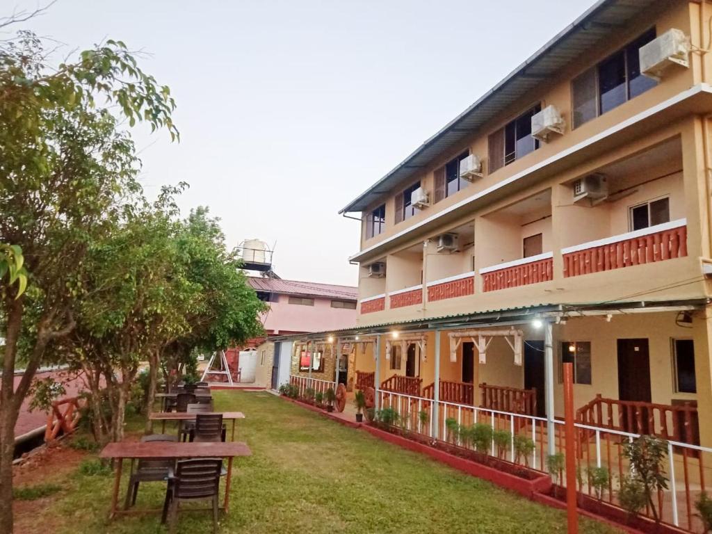 a courtyard of a hotel with tables and trees at Shivneri Holiday Resort in Mahabaleshwar