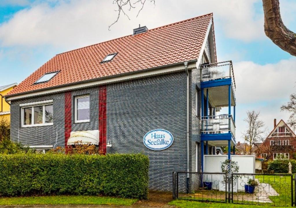 uma casa cinzenta com um telhado vermelho em Haus Seefalke - 250 m zum Meer em Cuxhaven