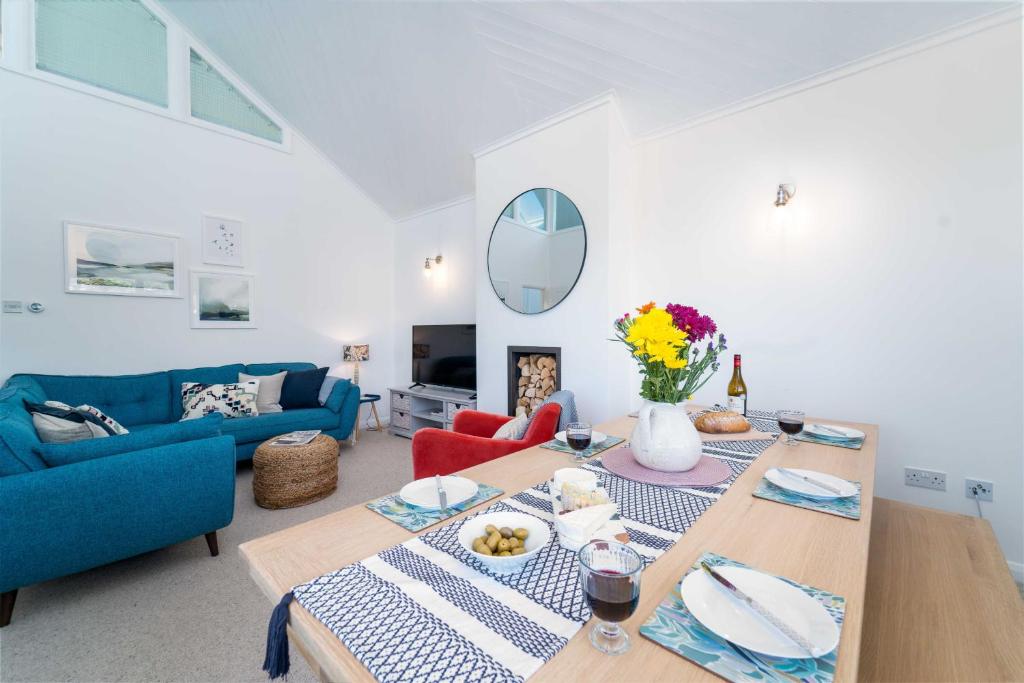 a living room with a table and a blue couch at Shearwater in Carbis Bay