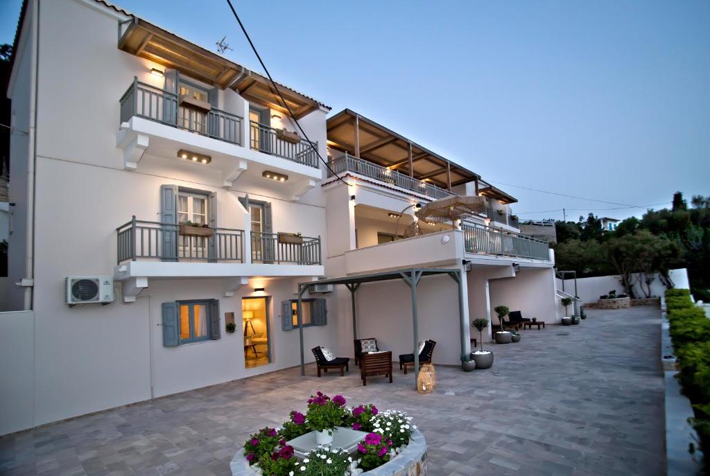a large white building with chairs and a patio at Horizon Hotel Kalymnos in Myrties