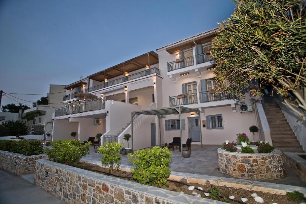 a large white building with a stone wall at Horizon Hotel Kalymnos in Myrties