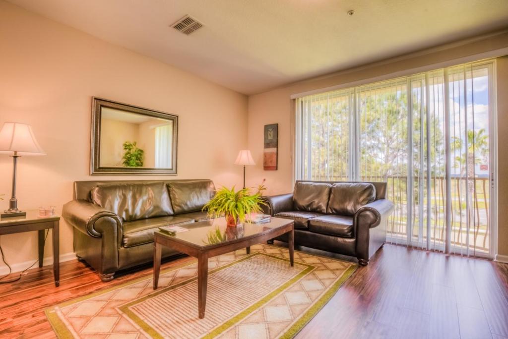 a living room with two leather couches and a table at Gorgeous Townhome w FREE Resort Access in Orlando
