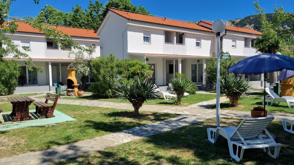 a patio with chairs and an umbrella in front of a building at Villas Corinthia in Baška