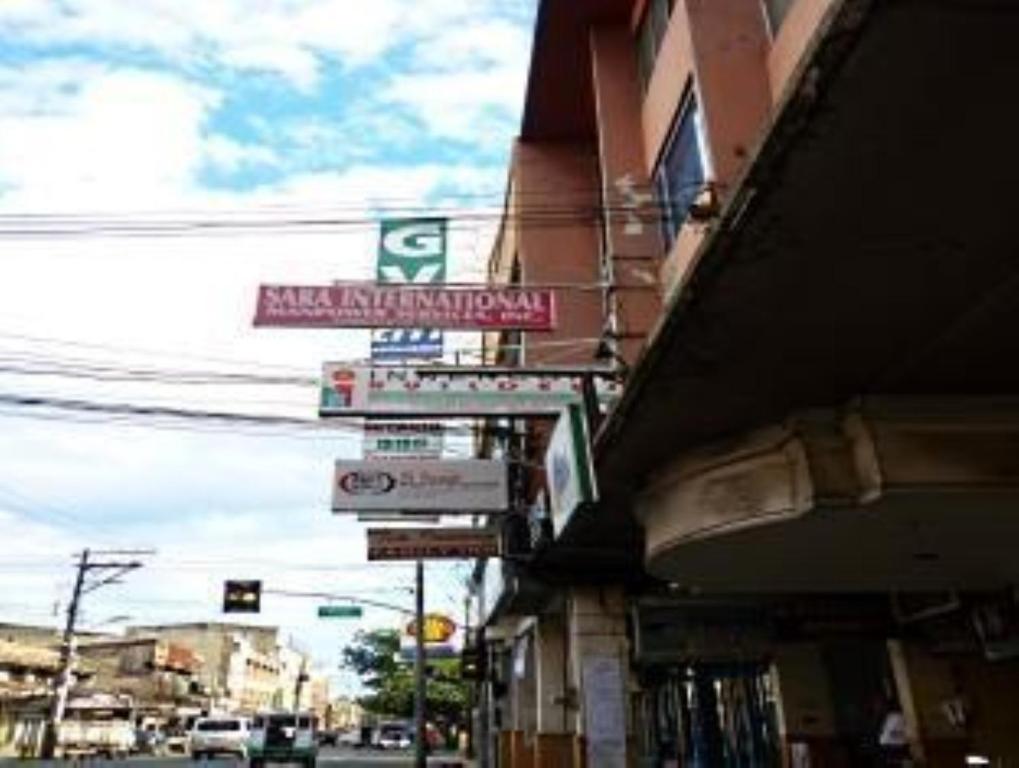 un edificio con cartelli sul lato di una strada di GV Hotel - Davao a Davao