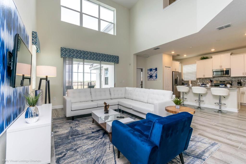 sala de estar con sofá blanco y sillas azules en Beautiful Home wPrivate Pool & Spa, near WDW en Kissimmee