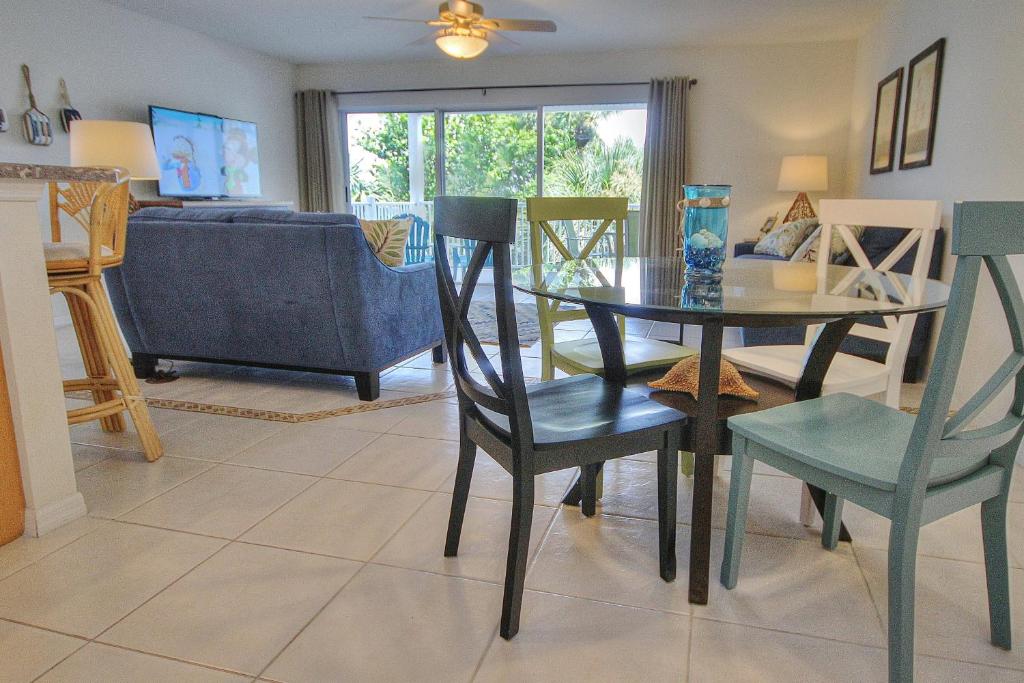 a living room with a table and chairs and a couch at Captain's Cove 304 in Clearwater Beach