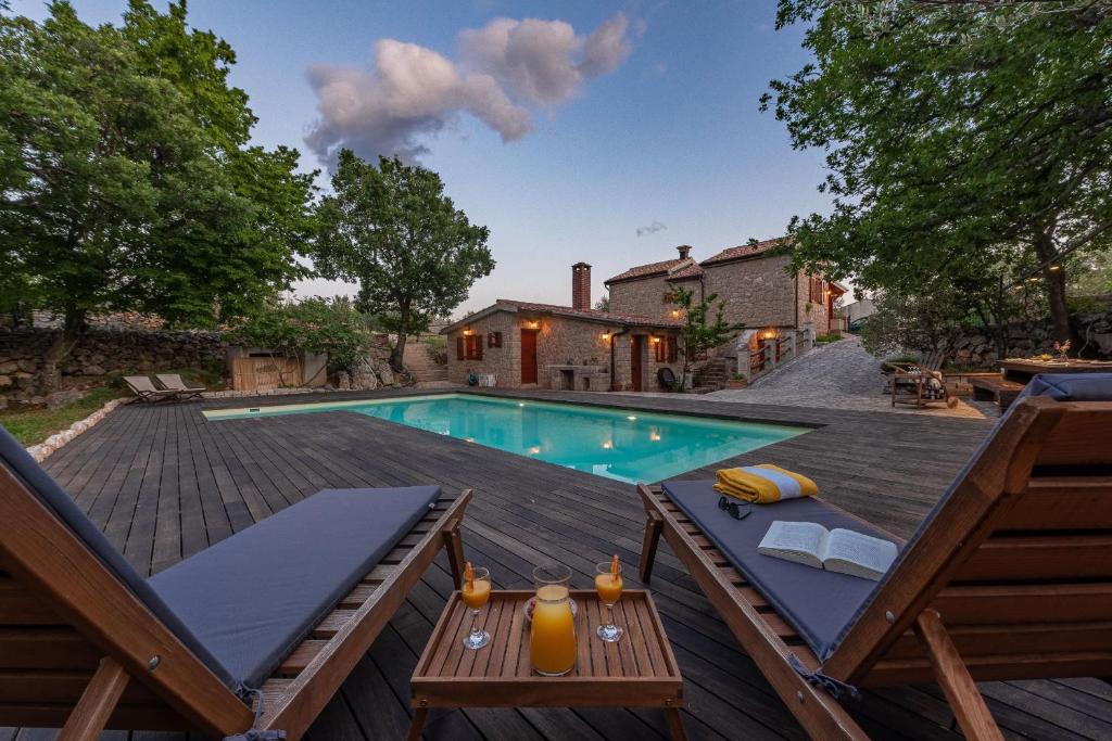 a swimming pool on a deck next to a house at Villa Stone House Magarac in Seline