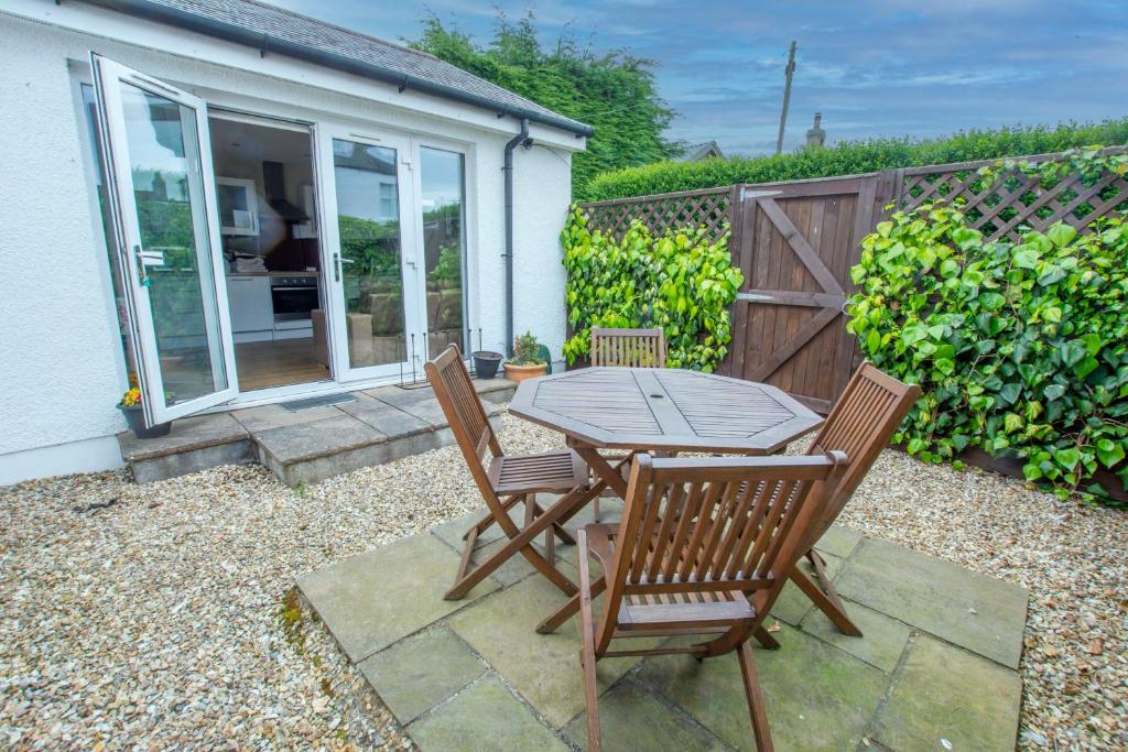 a patio with a table and chairs in front of a house at Helena Cottage in Elie