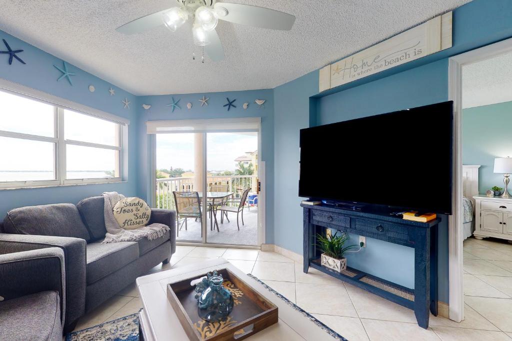 sala de estar con TV de pantalla plana grande en Sunrise Resort 509 en St Pete Beach