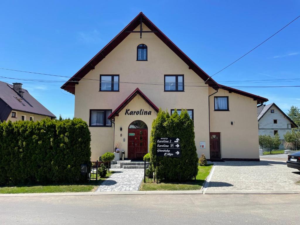 un gran edificio blanco con un cartel delante en Willa Karolina, en Czorsztyn