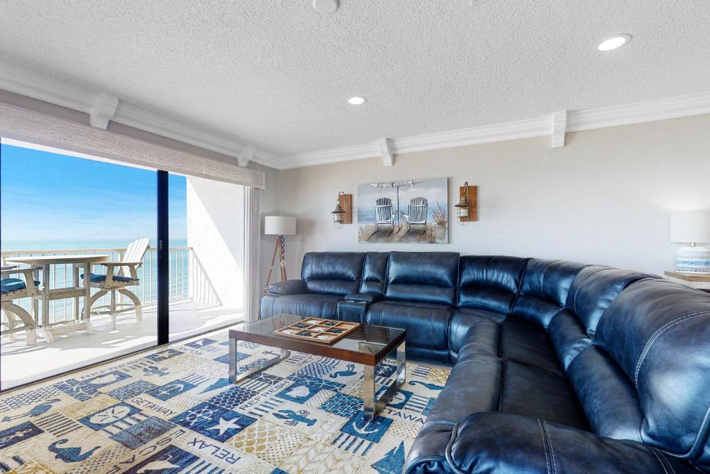 a living room with a leather couch and a table at The Pointe 301 in Clearwater Beach