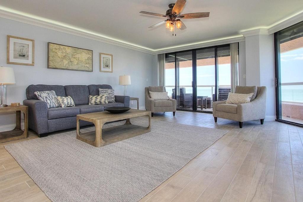a living room with a couch and chairs and a ceiling fan at Crescent Beach Club II 9A in Clearwater Beach