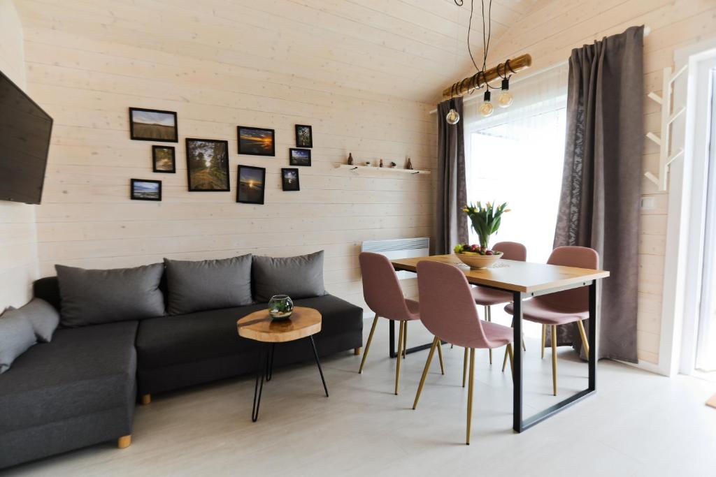 a living room with a couch and a table at Karuba Resort, Gdańsk - Wyspa Sobieszewska in Gdańsk