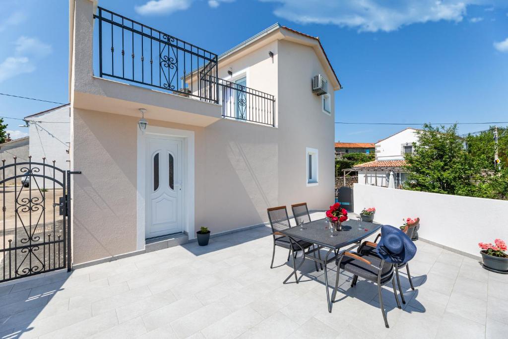 a patio with a table and chairs in front of a house at La Terza in Krk