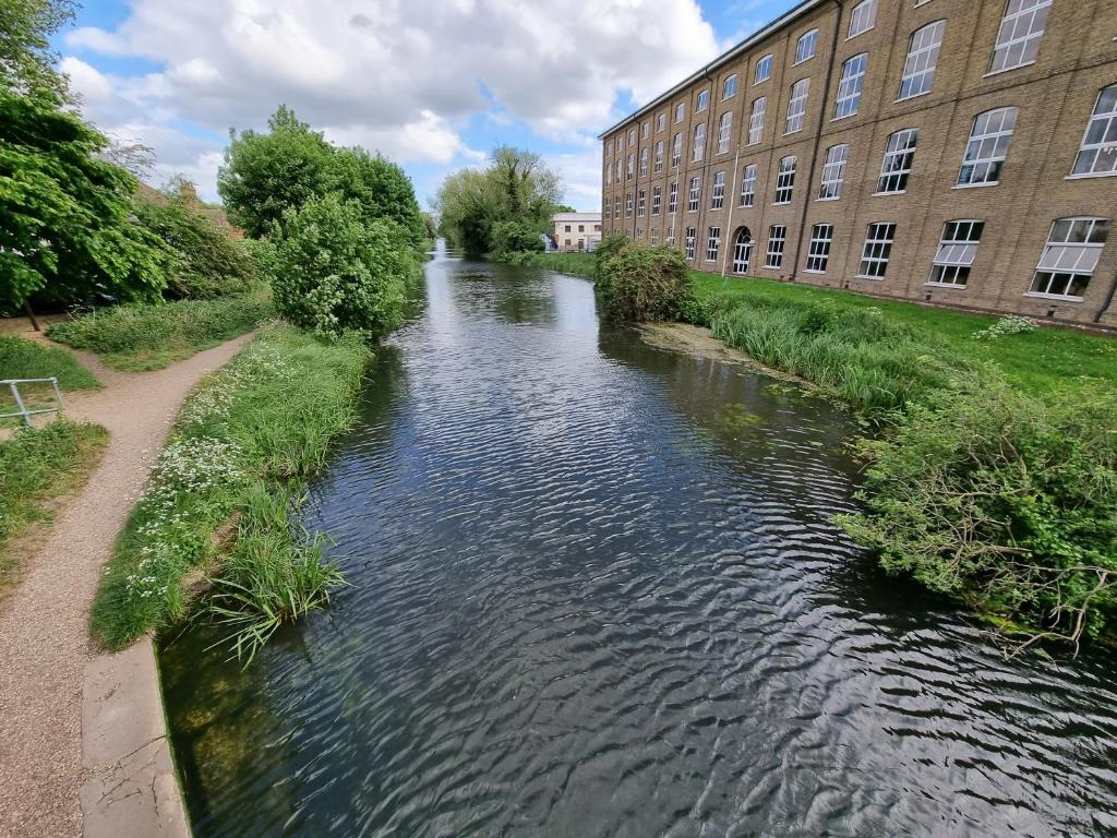 a river in front of a building next to a building at Canal Side Retreat - 2 Bedroom Apartment in Heybridge