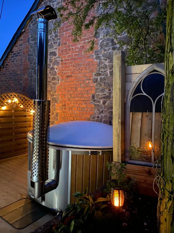 a bench sitting in front of a brick building at Luxury Mary's Croft with Swedish Hot tub and BBQ HUT in Shrewsbury