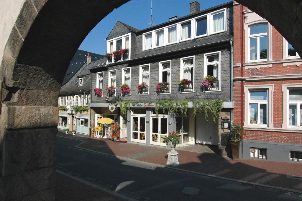 an archway over a street in a city with buildings at Hotel Garni Kaiserpfalz in Goslar