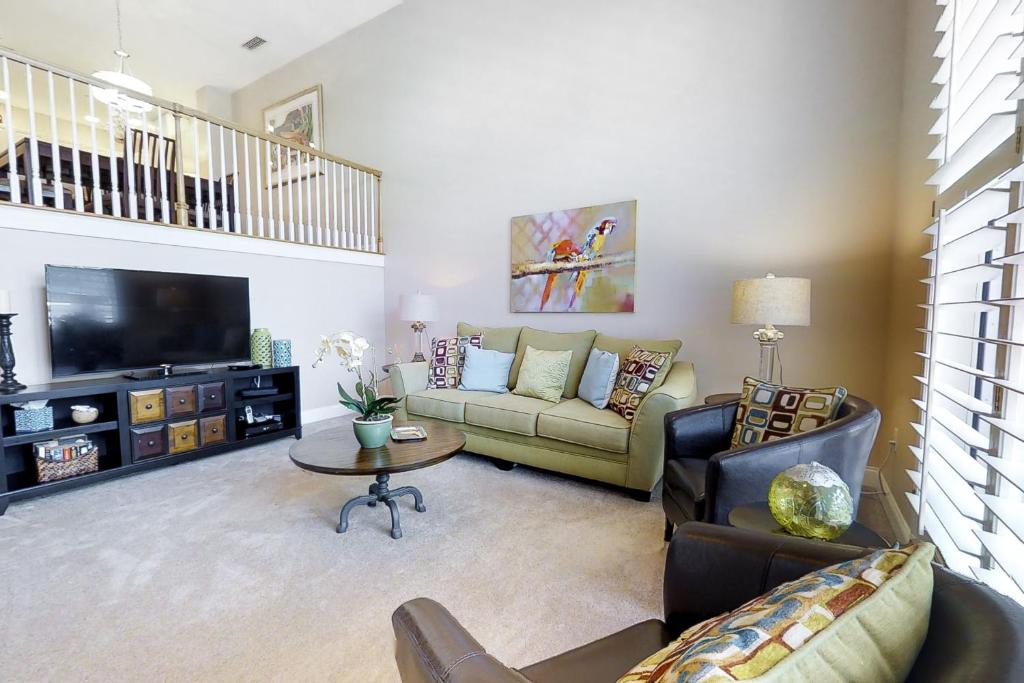 a living room with a couch and a tv at Belle Harbor 13 in Clearwater Beach