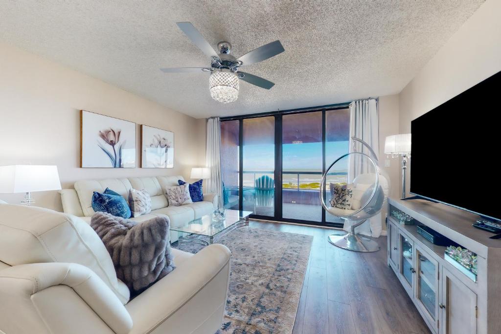 a living room with a white couch and a flat screen tv at Crescent Beach Club II 5B in Clearwater Beach