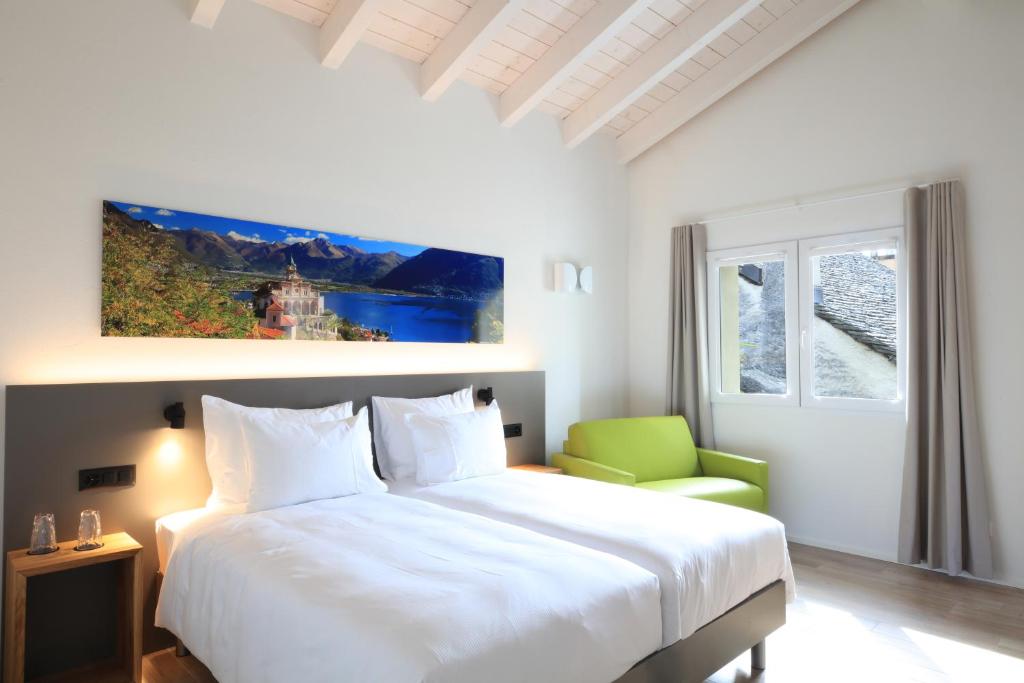 um quarto com uma cama branca e uma cadeira verde em Charme Hotel al Torchio em Ascona