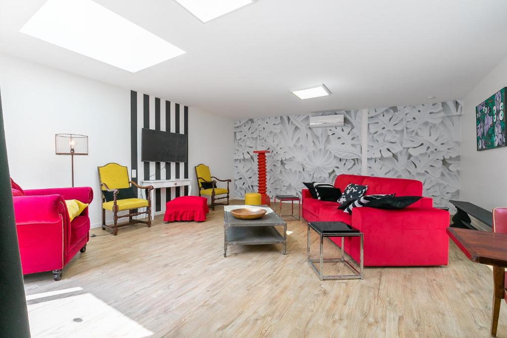 una sala de estar con 2 sofás rojos y una mesa. en Le B2, en Dijon