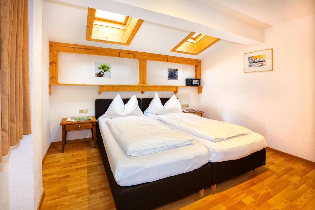 a bedroom with two beds with white sheets at Haus Veronika in Sölden