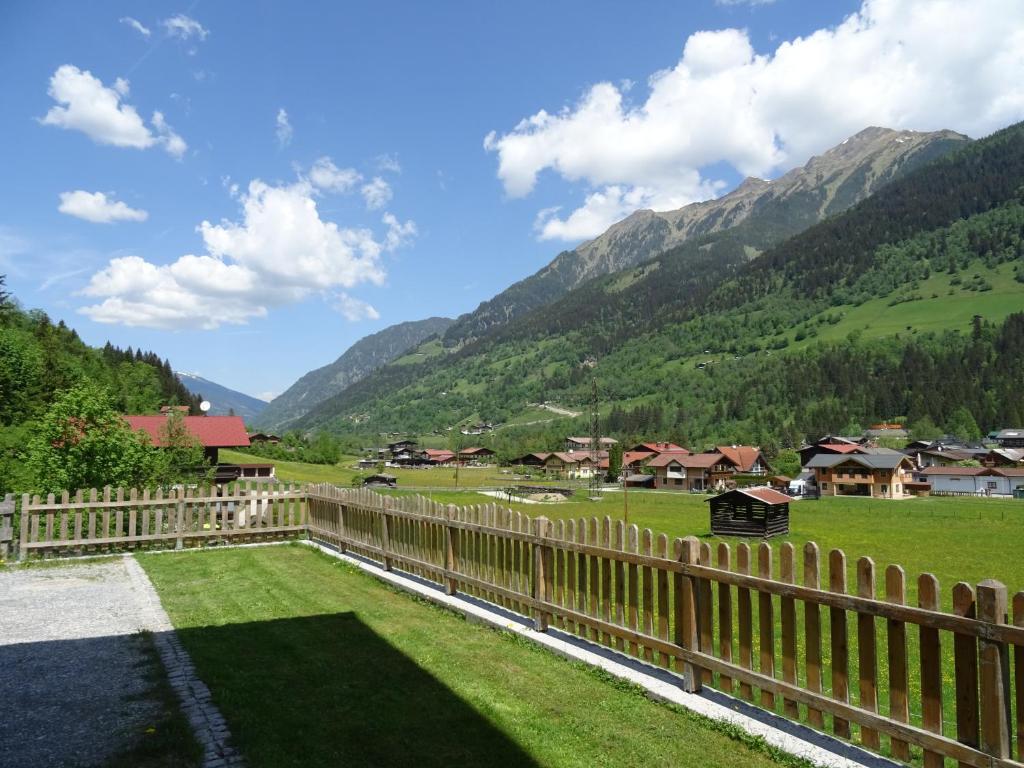 ogrodzenie w polu z górami w tle w obiekcie Appartement Klausner w mieście Bad Gastein