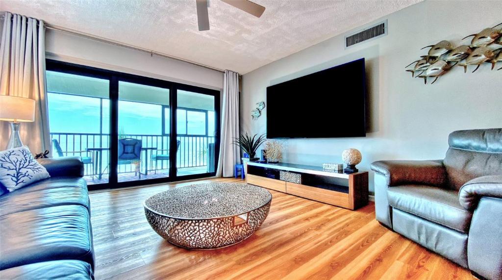 een woonkamer met een bank, een tafel en een tv bij Arie Dam 201 in St Pete Beach