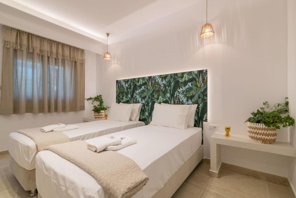 two beds in a room with white walls at Suncourt Lux Rooms in Laganas