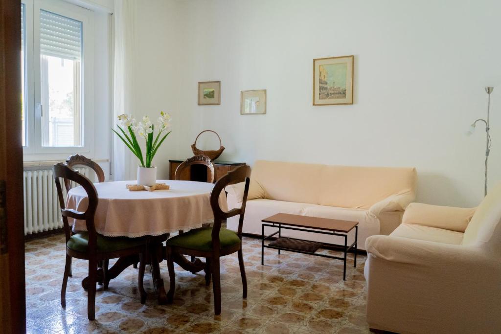 un soggiorno con tavolo e divano di Reno Family House a Ravenna