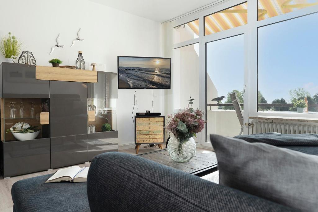 uma sala de estar com uma televisão e um sofá e uma televisão em Villa am Meer Pier 52 em Grömitz
