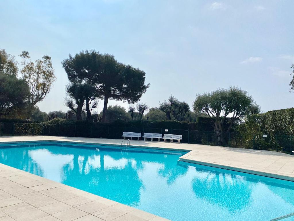 a swimming pool with a bench in a yard at Elia in Roquebrune-Cap-Martin