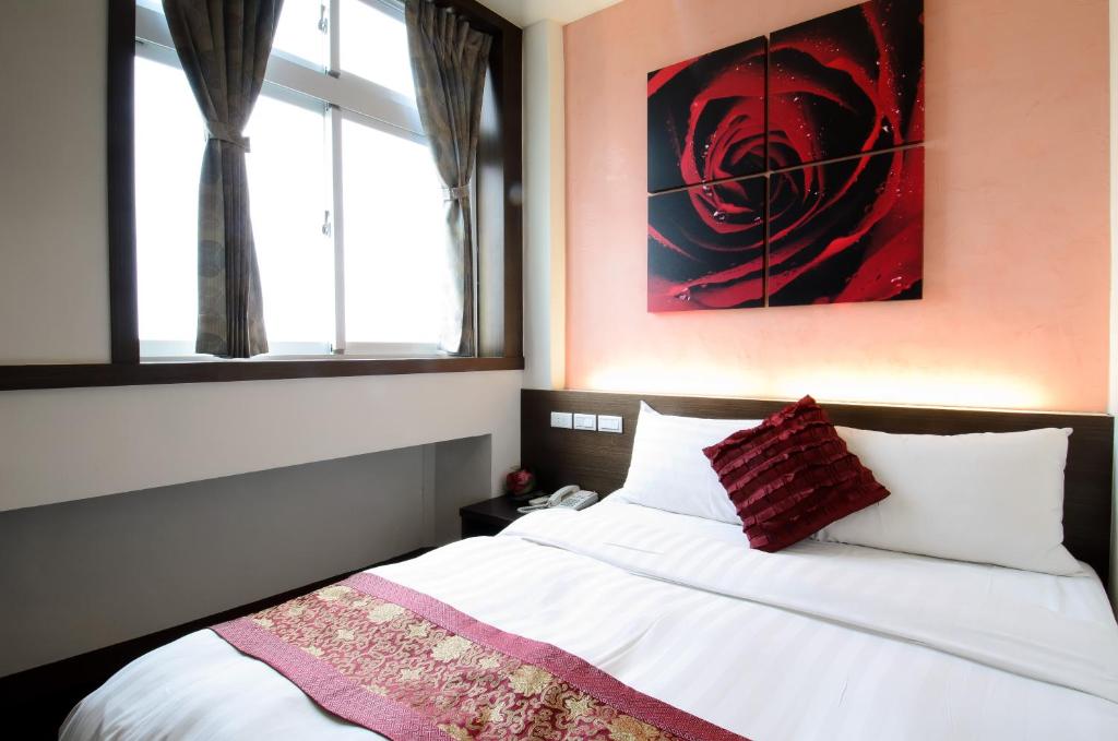 una camera da letto con un letto e un dipinto sul muro di Yuh-Tarng Hotel a Magong