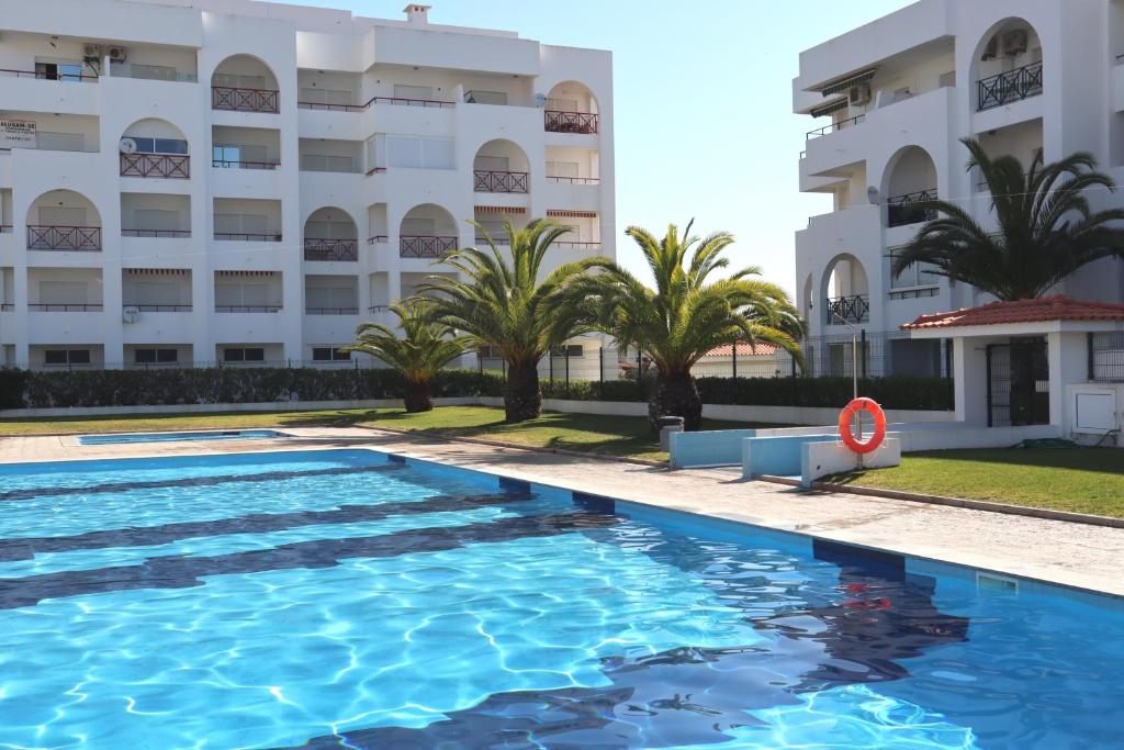 a swimming pool in front of a building at Apartamento Deolinda - Nossa Sra da Rocha in Porches