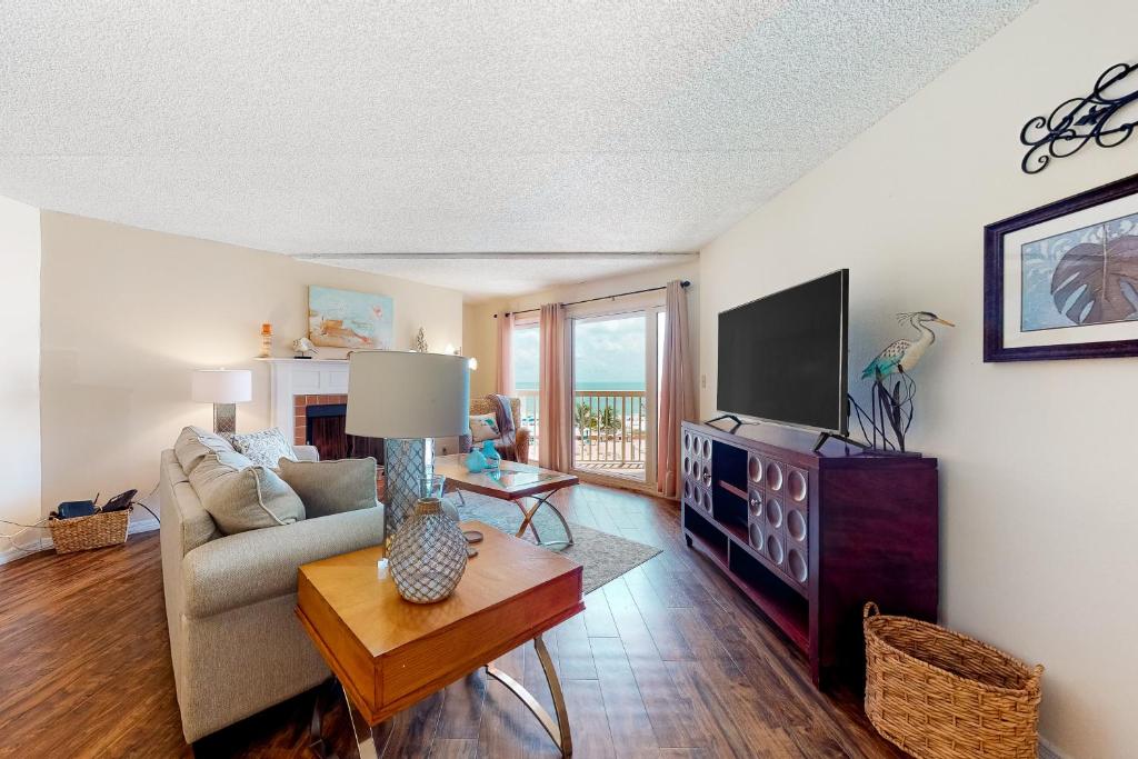 a living room with a couch and a tv at Beach Cottage 2402 in Clearwater Beach
