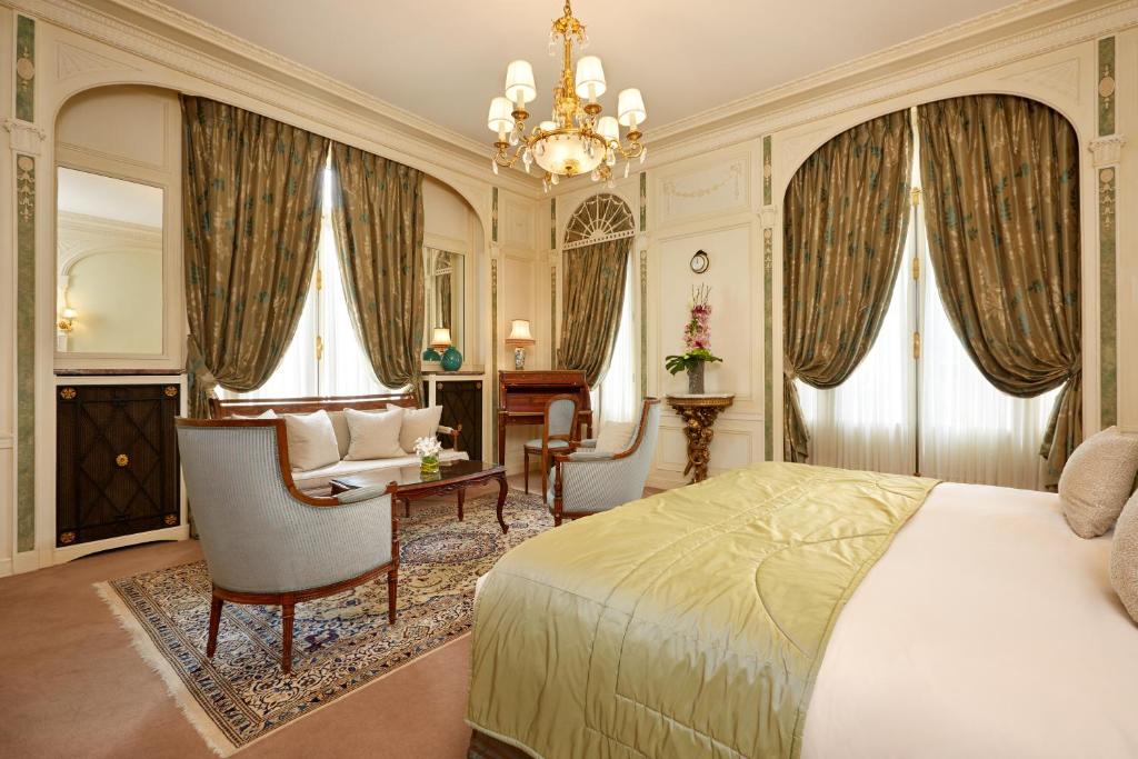 a bedroom with a bed and a chair and a desk at Hôtel Raphael in Paris