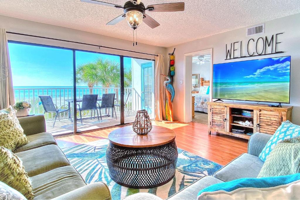 a living room with a tv and a couch and a table at Beach Palms 108 in Clearwater Beach