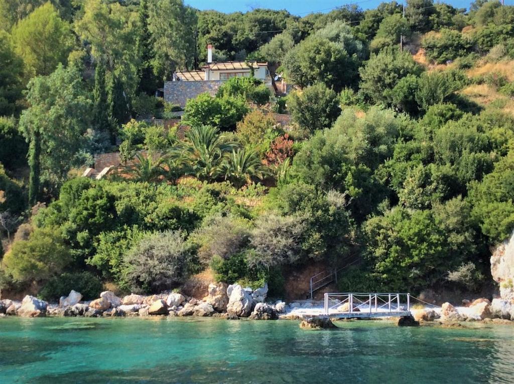 a bridge over a river with trees and a house at Alonissos Luxury Villa with Jacuzzi and Beach in Agios Dimitrios
