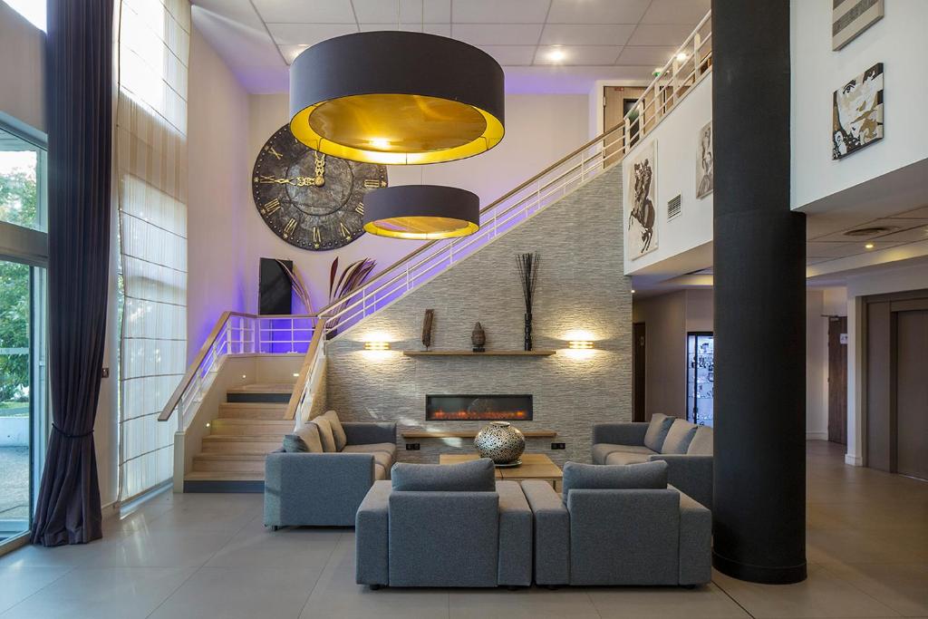 salon z kanapami i schodami w obiekcie HOTEL DU PARC Roissy Villepinte - Parc des Expositions w Roissy-en-France