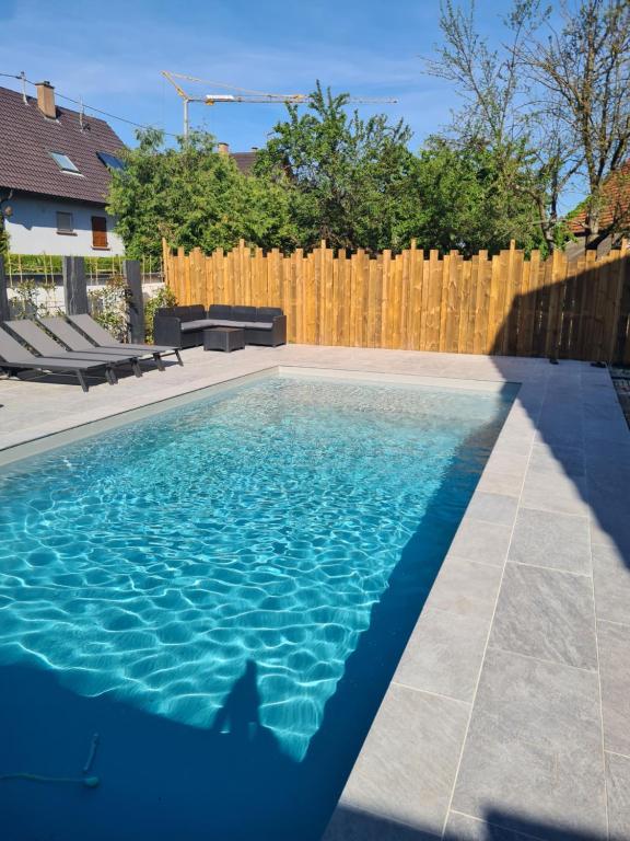 una piscina en un patio trasero con una valla de madera en Logement privé dans une Villa avec piscine en Dalhunden