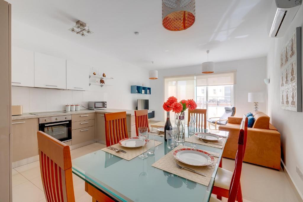 a kitchen and dining room with a table and chairs at Prime Location Apartment with Side Seaviews in Sliema