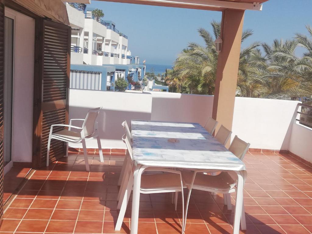 una mesa y sillas en un balcón con vistas al océano en Mojacar a, en Mojácar