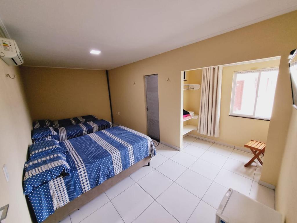 1 dormitorio con 1 cama con manta azul y blanca en Pousada Espaco Verde en Itarema