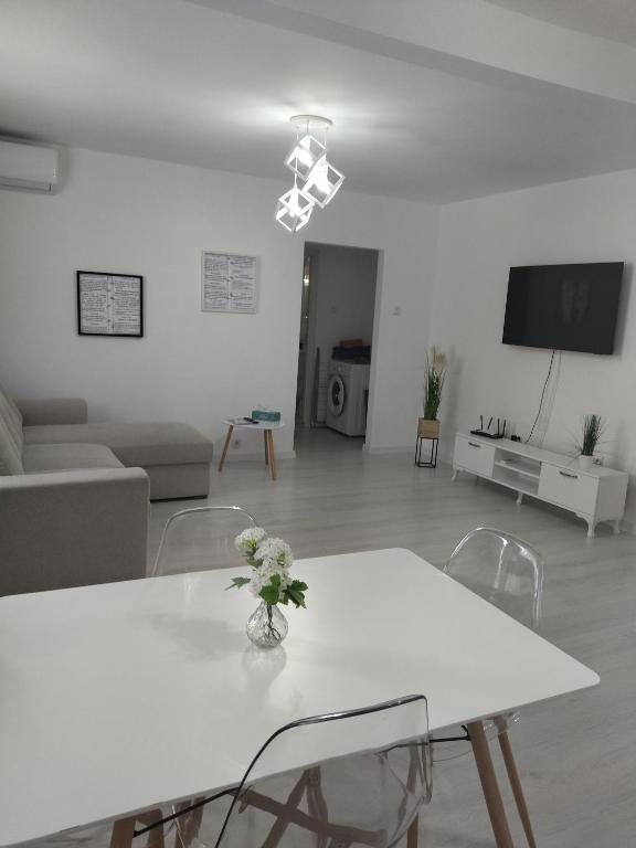 a white living room with a white table and chairs at Apartament max. confort in Tulcea