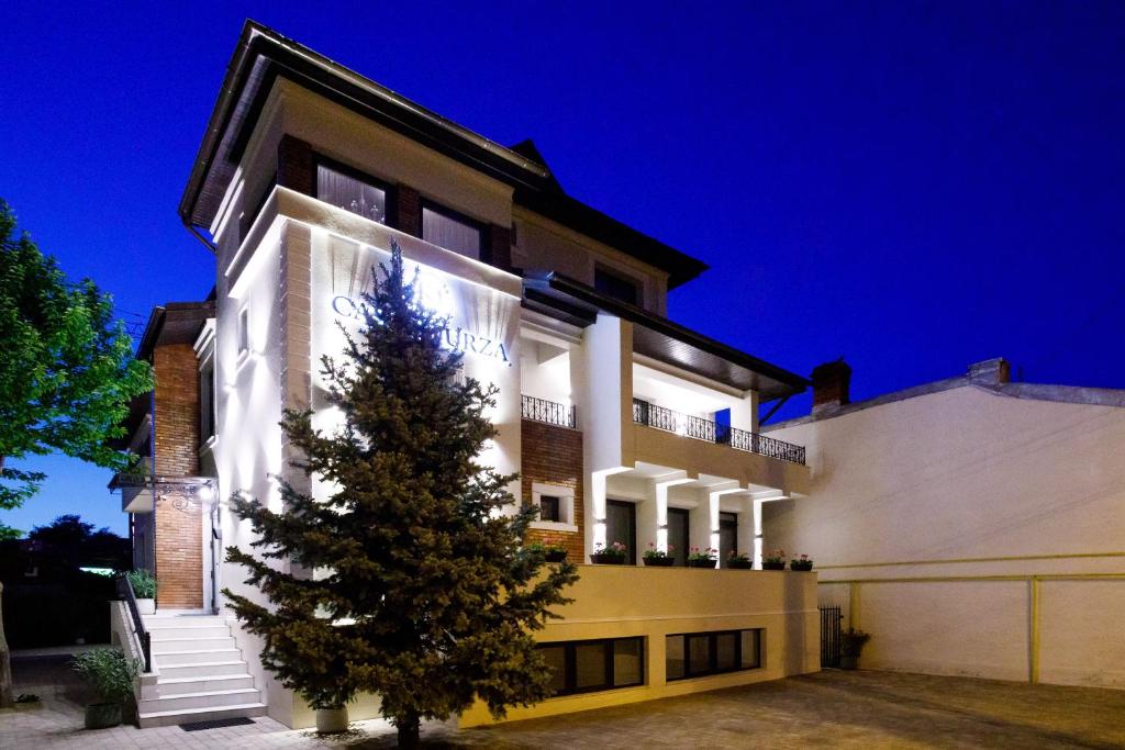 a building with a christmas tree in front of it at Pensiunea Casa Sturza in Bacău