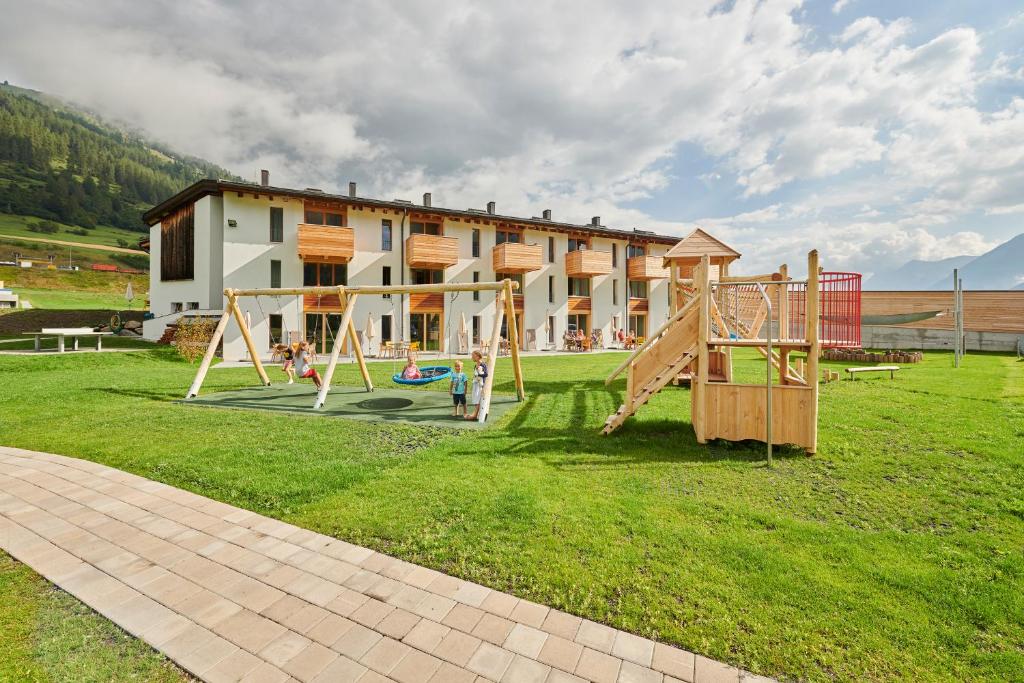 een park met een speeltuin met een gebouw op de achtergrond bij Reka-Ferienanlage Scuol in Scuol