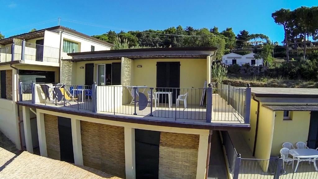 a house with a balcony with tables and chairs on it at Hotel Dino in Capoliveri