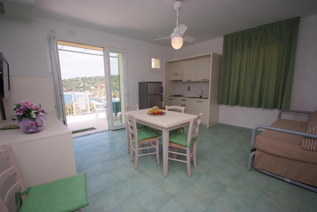 a kitchen and living room with a table and chairs at Hotel Dino in Capoliveri