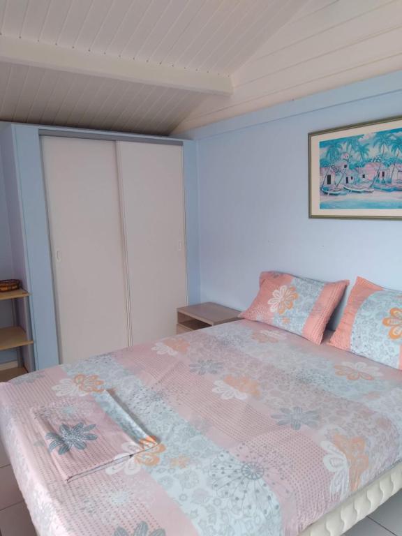 um quarto com uma cama com um cobertor rosa em Résidence Naturelle pour Naturistes em Le Moule